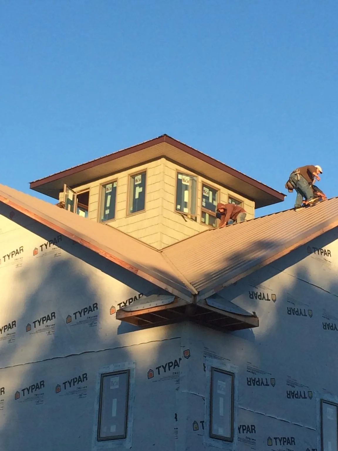 Roofers working around a rooftop cupola on a new metal roof at sunset — Roof Waterproofing in Oak Park by Roofing Brothers